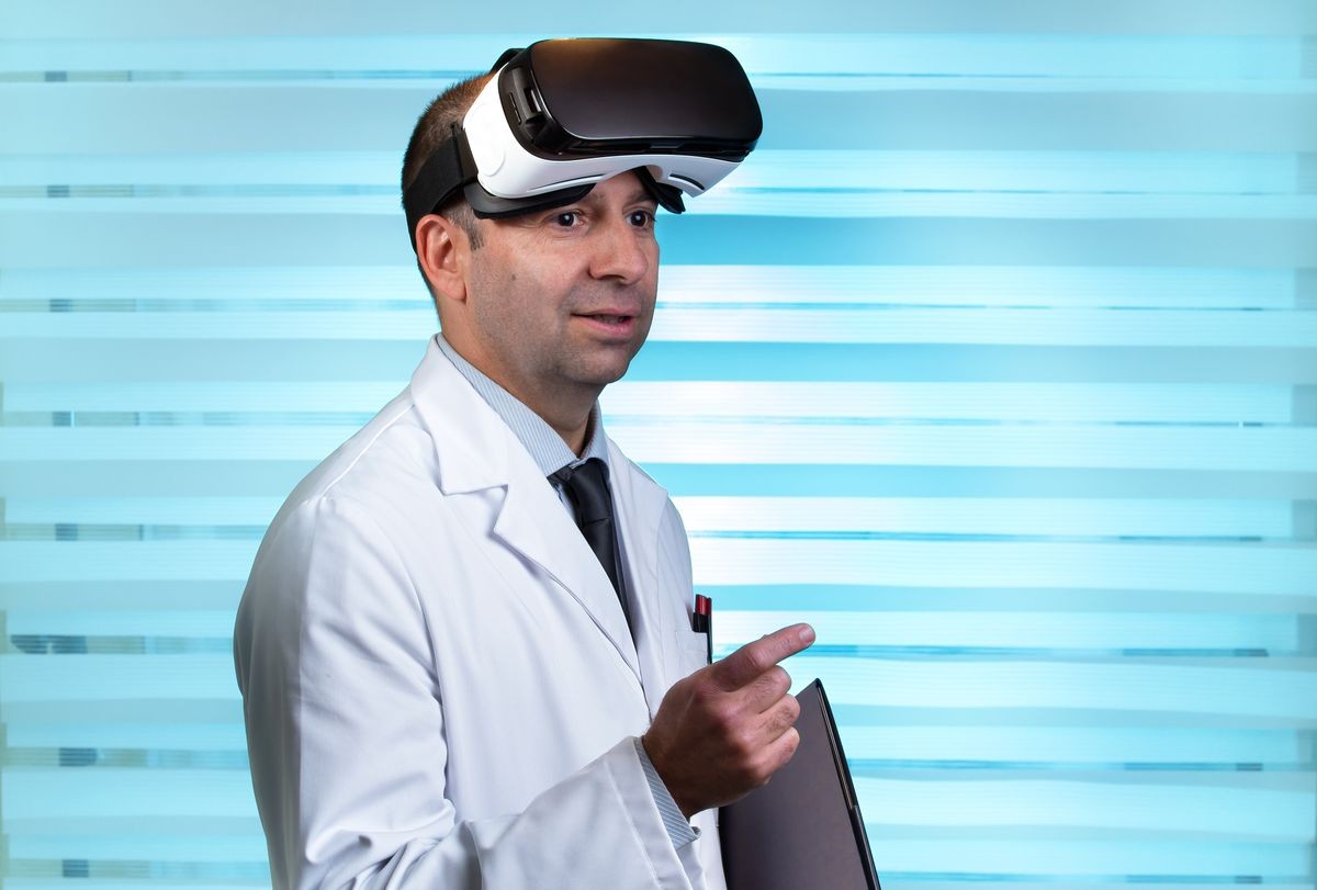 Practitioner with VR virtual reality glasses / Doctor wearing virtual reality glasses in clinical consultation